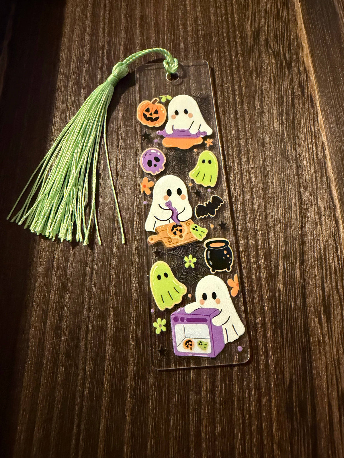 Halloween acrylic bookmark with a cute baking ghost design and cookies.  It has a matching light green tassel.