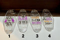 Four clear coffin-shaped acrylic keychains with glitter inside, each printed with a different Halloween-themed phrase: 'Boo to You,' 'Trick or Treat,' 'Double Toil & Trouble,' and 'Not Every Witch Lives in Salem.'.