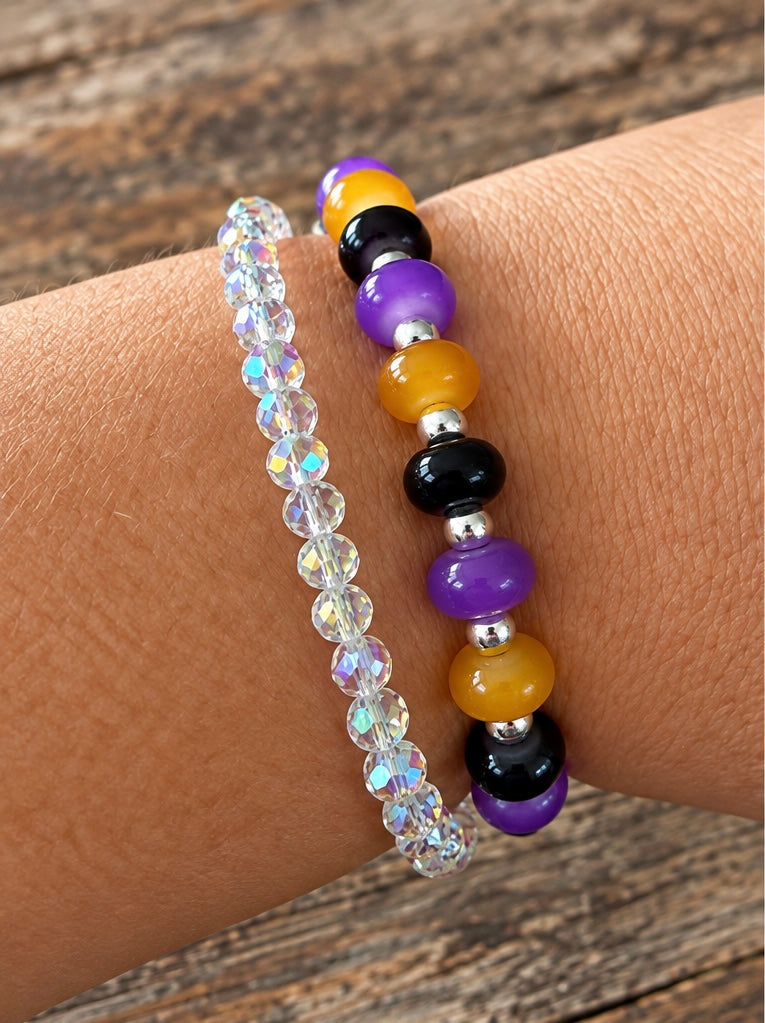 A black, purple, and orangish gold glass bead bracelet with silver spacer beads.  A magical stretch bracelet color combination.
