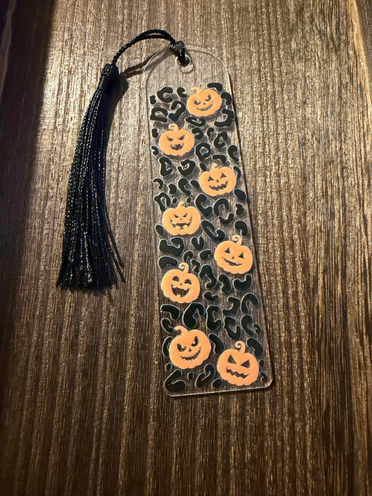 Halloween acrylic bookmark with leopard print and pumpkin design and matching black tassel.