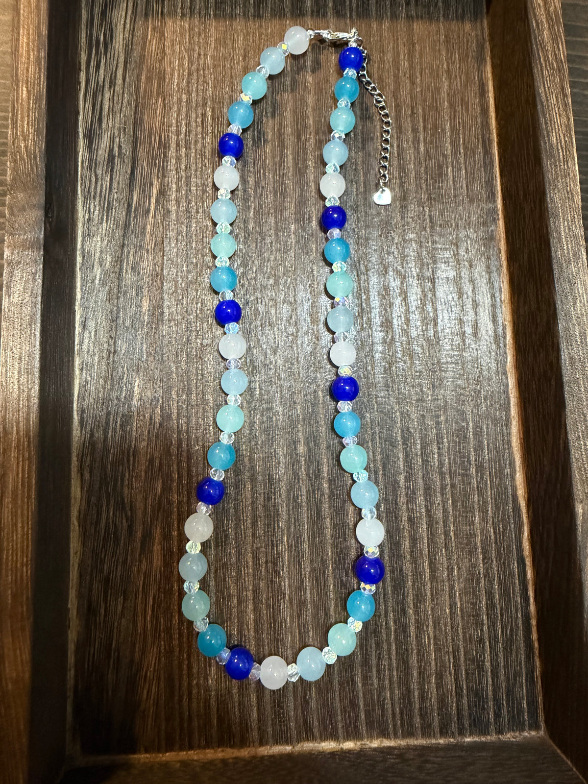 ocean inspired blue glass beaded necklace with four shades of blue glass beads, white glass beads, and 4mm white faceted Austrian glass spacer beads