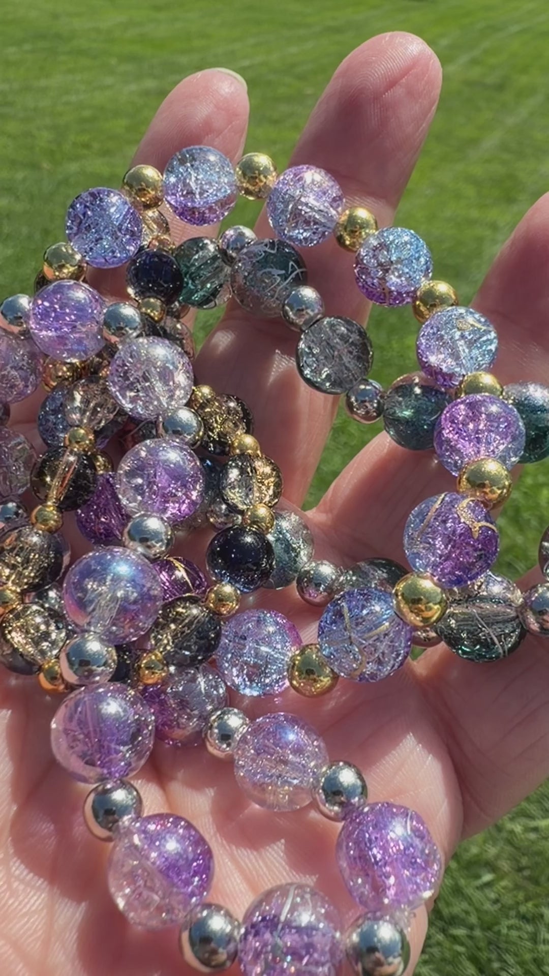 A video of several crackle glass bead bracelets sparkling in the sunlight.