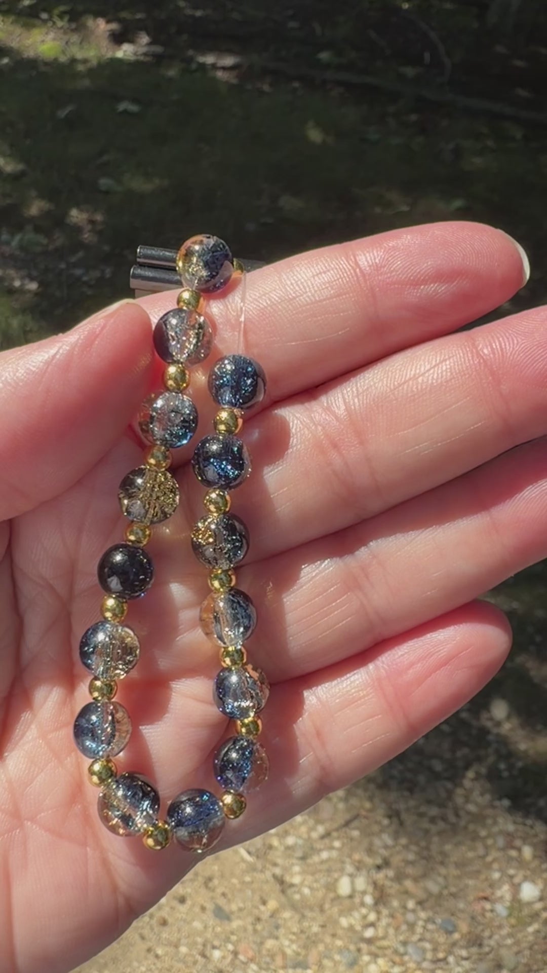 A video of the whimsigoth crackle glass bracelet sparkling in the sunlight